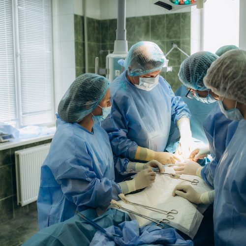 Surgical team performing surgery operation. Doctor performing surgery using sterilized equipment. Gynecologists and midwifes giving birth. Infant in maternity hospital Cirugía Nerv Sparing